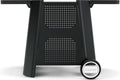 Nahaufnahme des unteren Teils des Cozze Outdoor-Tischs für E-500 Elektrogrill, G-500 Gasgrill und Plancha: schwarzer Metallständer mit zwei Beinen, perforierter Platte und einem runden "Cozze"-Rad - perfektes Pizzaofen-Zubehör.