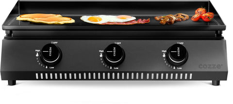 Die Cozze G-700 Plancha, Gas 50mbar - CH-Regler verfügt über drei Bedienknöpfe und eine emaillierte Kochfläche, ideal für die Zubereitung von Pfannkuchen, Eiern, Speck, Pilzen und Kirschtomaten. Auf der Vorderseite befindet sich das Cozze-Logo.