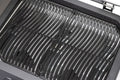 Nahaufnahme eines sauberen, leeren Metallrosts im Inneren eines Cozze G-500 Grill, Gas 50mbar - CH-Regler von Cozze. Die glänzenden schwarzen Roste sind in parallelen Linien angeordnet - ideal für Ihren kompakten Gasgrill auf der Terrasse.