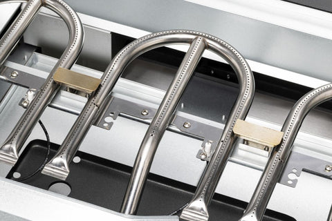 Nahaufnahme der U-förmigen Gasbrenner aus Edelstahl im Inneren der Cozze G-800 Plancha mit Deckel, Gas 50mbar - CH-Reglergrill von Cozze, mit Metallhalterungen und Brennerlöchern für gleichmäßige Flammen - ideal für Ihre Outdoor-Küche.