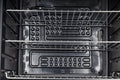 Eine Nahaufnahme des Innenraums des Cozze Kühlschrank 60L mit Stahlrahmen (elektrisch 230V, CH-Stecker), wobei die Metallgestelle und die am Boden montierten Heizelemente hervorgehoben werden.
