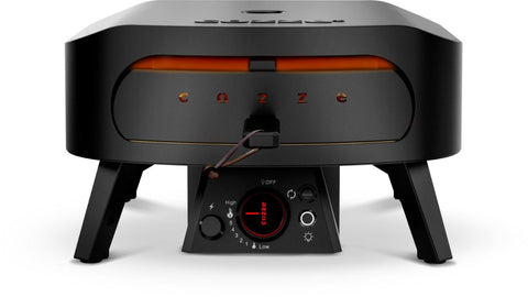 Frontansicht des Cozze Pizzaofen Rotate - Black Edition [13 Zoll], Gas, 50mbar - CH-Regler, zeigt rotierenden Pizzastein, orangefarbenes Glühen im Inneren, Bedienknopf, Zündschalter und Cozze-Logo auf der Frontplatte.