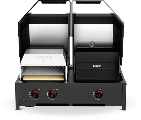 Der Cozze Grill Quattro 900 ist ein Zweikammer-Gasofen für den Außenbereich mit zwei offenen Deckeln, die links einen Keramik-Pizzastein und rechts ein Infrarot-Grillfach aufweisen. Drei rote Knöpfe betonen die Frontplatte.