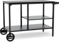 Die Cozze Elements BBQ Station ist ein schwarzer Metallwagen mit zwei Rädern, zwei Ablagen und einem Griff für einfache Mobilität. Das "cozze"-Logo auf einem Rad unterstreicht seine Verwendung als Outdoor-Küche oder mobile Edelstahl-Arbeitsfläche.