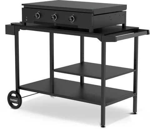 Die Cozze Elements BBQ Station ist ein schwarzer Outdoor-Grillwagen mit flacher Grillplatte, Bedienknöpfen, zwei Ablagen, seitlichem Griff und Rädern - ideal für Ihre Outdoor-Küche. Die Marke Cozze erscheint auf dem Rad.