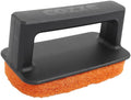 Der Cozze Plancha-Scheuerschwamm ist ein schwarzer Handschrubber mit rechteckigem Griff und orangefarbenem Schleifpad, der für die effektive Reinigung von Plancha-Oberflächen konzipiert ist. Der Griff ist mit dem geprägten Cozze-Markennamen versehen.