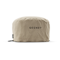 Die Arc Lite Abdeckhaube von Gozney ist eine beigefarbene Stoffhülle mit aufgedrucktem "GOZNEY", schwarzen verstellbaren Kordelzügen und abgesteppter Unterkante. Entworfen, um als Ofen Schutzhülle gut zu passen. Der Hintergrund ist einfarbig weiß.