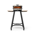 Das Gozney ARC und ARC XL Gestell ist ein moderner Outdoor-Pizzaofen auf Rädern, der mit klappbaren Holzseitentischen und einem stabilen schwarzen Ständer mit Ablagefläche ausgestattet ist. Sein Metallofen verfügt über eine runde Edelstahl-Backkammer und einen sichtbaren Bedienknopf an der Vorderseite, der sowohl Funktionalität als auch leichte Manövrierbarkeit gewährleistet.