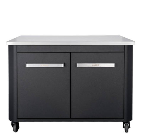 Die Cozze Aussenküche 90 eignet sich perfekt für jede Outdoor-Einrichtung. Sie verfügt über einen schwarzen Unterbau mit Schranktüren, eleganten silbernen Griffen und einer Edelstahlplatte. Dank der Rollen ist sie überall leicht beweglich.
