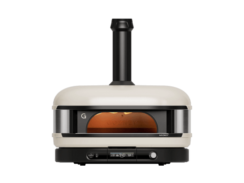 Ein cremefarbener Gozney Dome Gen 2 Pizzaofen - Hybrid Brennstoffsystem von Gozney mit Schornstein, Glasfrontfenster und Bedienknöpfen wird von vorne auf einem schlichten weißen Hintergrund gezeigt.