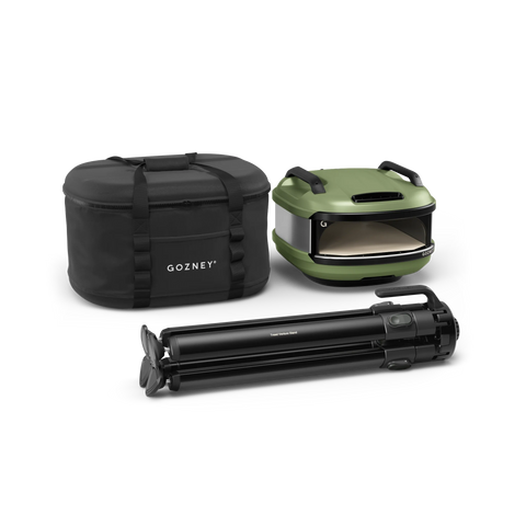 Das Gozney Tread Outdoor Bundle besteht aus einem grünen Pizzaofen, einer schwarzen "Gozney"-Transporttasche und einem gefalteten schwarzen Ständer - ideal für Ihre Outdoor-Küche und auf weißem Hintergrund abgebildet.