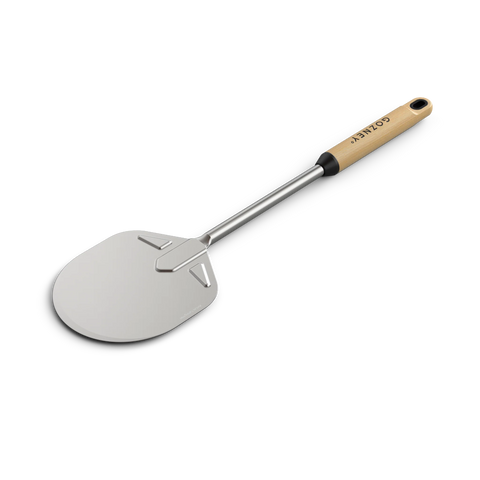 Der Gozney Venture Runder Pizzawender (15 cm) von Gozney verfügt über eine glatte, runde Edelstahlklinge mit einem langen Buchenholzgriff, der über ein Loch zum Aufhängen verfügt und mit Metall an der Schaufel befestigt ist. Vor einem schwarzen Hintergrund vereinen sich Stil und Funktion.