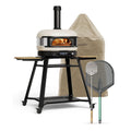 Cremefarbenes Gozney Dome Gen 2 Komplett-Set mit einem brennenden Feuer im Inneren, montiert auf einem schwarzen Ständer mit Rollen, inklusive Schutzhülle, Pizzaschaufel und Wendeschaufel.