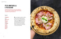 Eine Hand hält einen runden Holzteller mit Teichners Pizza Passion von Sven Teichmann, belegt mit Mortadella, Pistazien, Käseklecksen, Basilikum und geschichteter roter Tomatensauce auf goldbrauner Kruste.