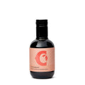 Eine kleine dunkle Glasflasche mit schwarzem Deckel ist zu sehen. Das pfirsichfarbene Etikett ist mit einem großen, stilisierten „C“ und einem abstrakten Design verziert. Der Text auf dem Etikett lautet „Olio aromatico al peperoncino“ und verrät, dass es sich um Ciccolellas extra natives Olivenöl mit Chiliaroma handelt, das in der Größe 100 ml erhältlich ist.