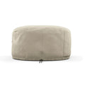 Eine beige, runde, zylindrische Gozney ARC + ARC XL Abdeckhaube kurz, die zum Schutz eines Gegenstands ähnlicher Form und Größe entwickelt wurde. Sie verfügt über eine kleine Tasche auf einer Seite und einen Riemen mit einer Schnalle an der Unterseite zur Befestigung. Das wetterfeste Material bietet dauerhaften Schutz vor den Elementen.