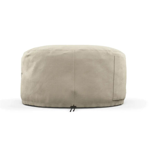 Eine beige, runde, zylindrische Gozney ARC + ARC XL Abdeckhaube kurz, die zum Schutz eines Gegenstands ähnlicher Form und Größe entwickelt wurde. Sie verfügt über eine kleine Tasche auf einer Seite und einen Riemen mit einer Schnalle an der Unterseite zur Befestigung. Das wetterfeste Material bietet dauerhaften Schutz vor den Elementen.
