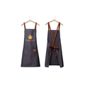 Zwei schwarze Pizzalovers-Schürzen hängen auf Kleiderbügeln. Die vordere Schürze, Pizzalovers Pizzaiolo Schürze, ist mit einem leuchtenden Flammenlogo und dem Text „Pizza Lovers“ versehen und hat zwei praktische Taschen. Die hintere Schürze hat verstellbare braune Lederriemen, die sich überkreuzen und in der Taille gebunden werden, was sie zur idealen Wahl für jeden Pizzaiolo in einer Pizzaküche macht.