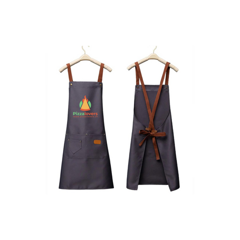 Zwei schwarze Pizzalovers-Schürzen hängen auf Kleiderbügeln. Die vordere Schürze, Pizzalovers Pizzaiolo Schürze, ist mit einem leuchtenden Flammenlogo und dem Text „Pizza Lovers“ versehen und hat zwei praktische Taschen. Die hintere Schürze hat verstellbare braune Lederriemen, die sich überkreuzen und in der Taille gebunden werden, was sie zur idealen Wahl für jeden Pizzaiolo in einer Pizzaküche macht.