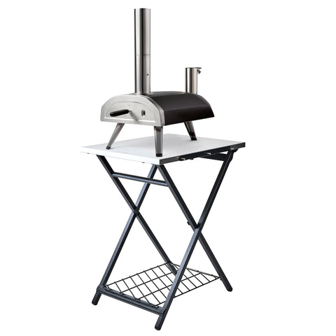 Ein Ooni Klapptisch mit einem eleganten Ooni-Pizzaofen aus Edelstahl steht auf einem klappbaren weißen Tisch mit einem unteren Gitterrost. Der Kamin und das kompakte Design des Ofens machen ihn perfekt für den mobilen Einsatz, ideal für jede Pizza-Party.